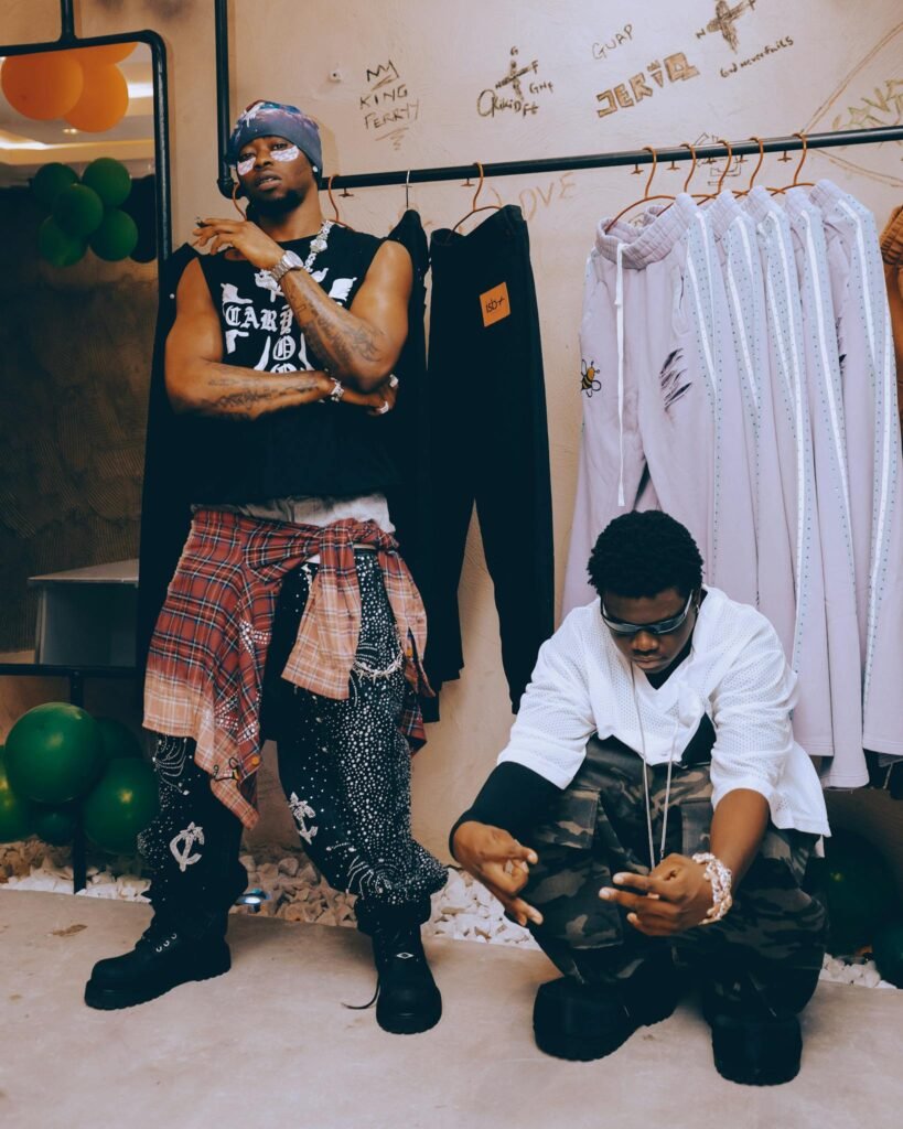 Two fashion-forward individuals pose in a trendy clothing store, showcasing unique styles.